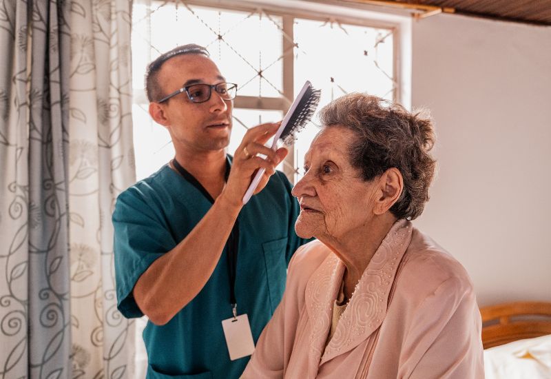 Caregiver combing a senior woman's hair